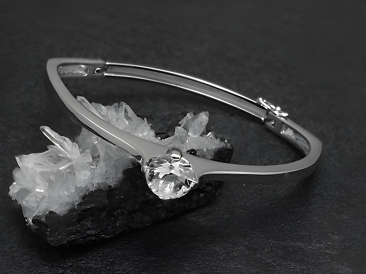 Silber Armreifen edel 11,2 mm rhodiniert 17 cm Hersteller Juwelier Harnisch mit strahlendem Stein, auf dunklem Hintergrund und in eleganter Präsentation.