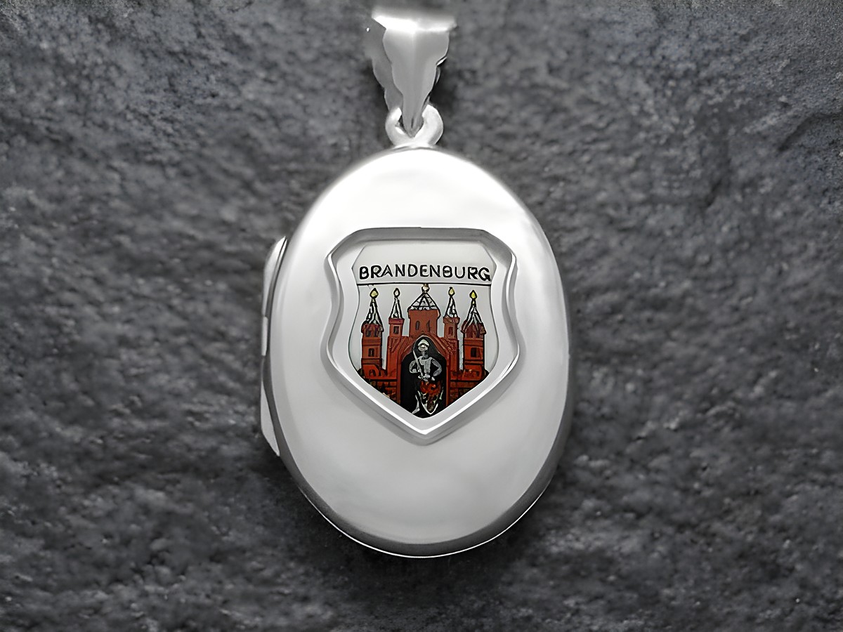 Ein silbernes Medaillon mit dem Wappen von Brandenburg, das eine farbige Darstellung des Wappens zeigt, umrandet von einem schlichten, glänzenden Rahmen.
