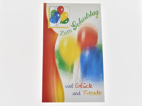 Eine Geburtstagskarte mit bunten Luftballons in Gelb, Rot und Blau. Der Schriftzug Zum Geburtstag und viel Glück und Freude ziert die Karte. Hersteller Juwelier Harnisch.