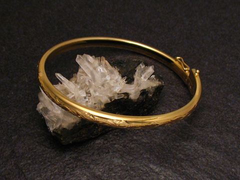 Märchenhafter Goldarmreifen von Juwelier Harnisch mit einer Breite von 4,7 mm und einer Länge von 20 cm, auf einem schwarzen Untergrund mit Kristallen präsentiert.