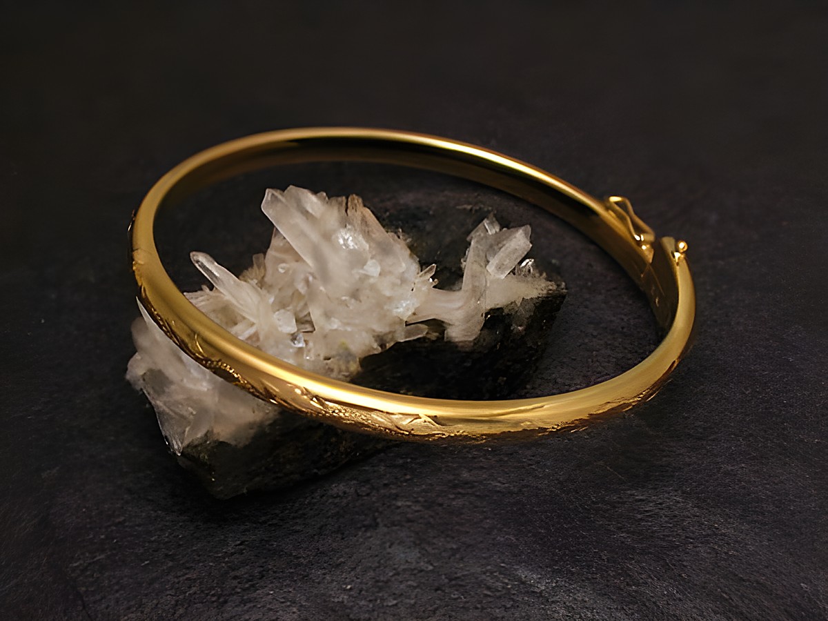 Märchenhafter Goldarmreifen von Juwelier Harnisch mit einer Breite von 4,7 mm und einer Länge von 20 cm, auf einem schwarzen Untergrund mit Kristallen präsentiert.