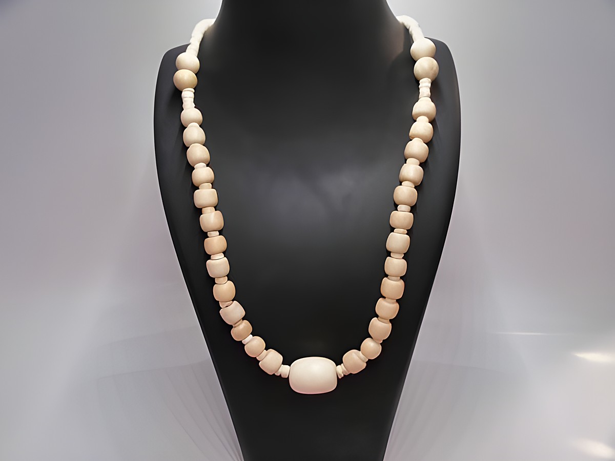 Holzkette Multiform 22 mm naturbraun 60 cm aus Holzschmuck von Juwelier Harnisch, zeigt eine vielfältige Anordnung von Holzperlen in verschiedenen Formen und Tönen auf einer Darstellung.