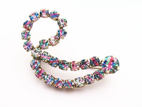 Strass Brosche in geschwungener Form, bunt und gefasst, neu, vom Hersteller Juwelier Harnisch. Die Brosche hat eine ansprechende Kombination aus bunten und weißen Strasssteinen.