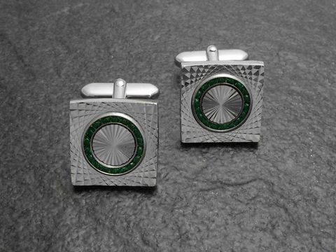 Manschettenknöpfe in Silberfarbe mit feinem grünen Strass von Juwelier Harnisch, verziert mit Strasssteinen und einem eleganten, eingefrästen Muster.