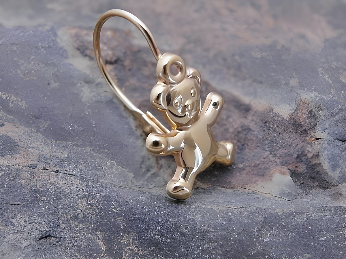 Ein unisex Ohrstecker in Form eines verspielten Teddybären aus Gold, hergestellt von Juwelier Harnisch, Einzelstück, ideal für eine liebevolle und charmante Note.