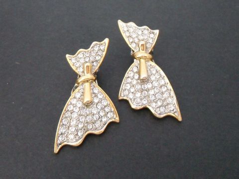 Ohrclips in gold- und silberfarben mit einer silberfarbenen Schleife und Strassverzierung, Hersteller Juwelier Harnisch, ideal für elegante Anlässe.