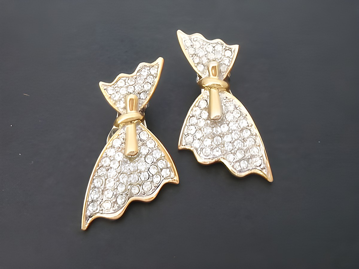 Ohrclips in gold- und silberfarben mit einer silberfarbenen Schleife und Strassverzierung, Hersteller Juwelier Harnisch, ideal für elegante Anlässe.