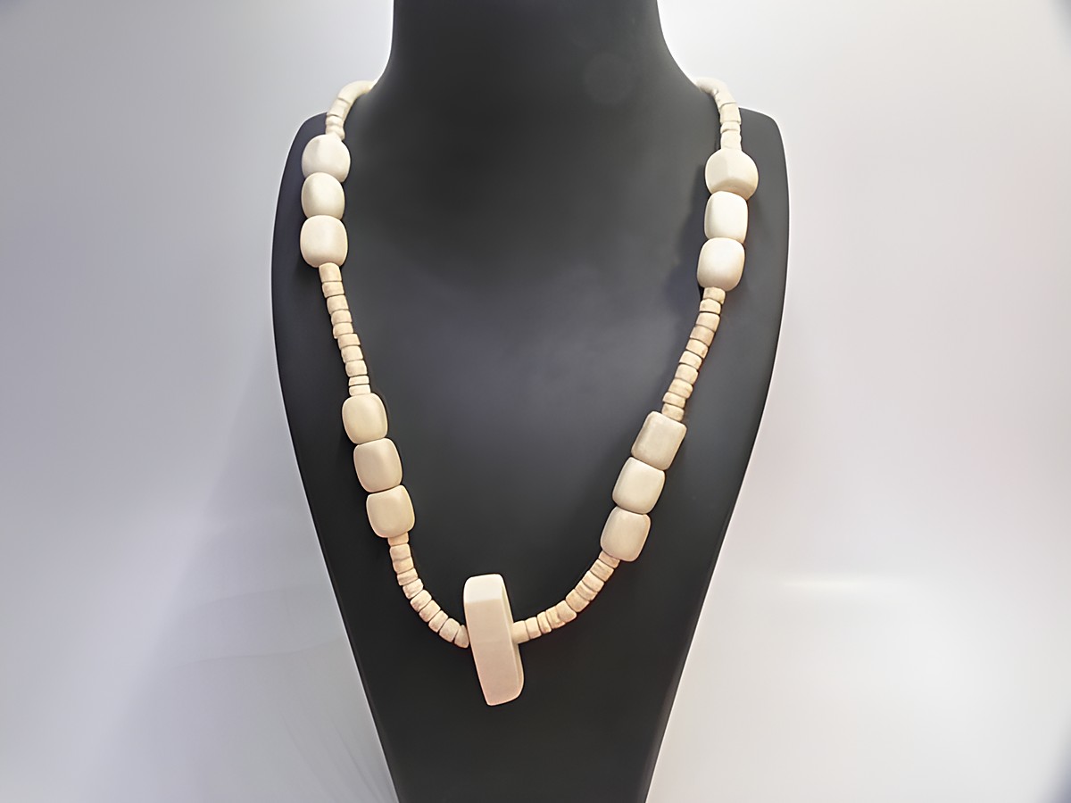Holzkette Multiform 35 mm naturbraun 60 cm aus Holzschmuck von Juwelier Harnisch, zeigt ein harmonisches Design mit verschiedenen Holzperlen und einem zentralen Element.