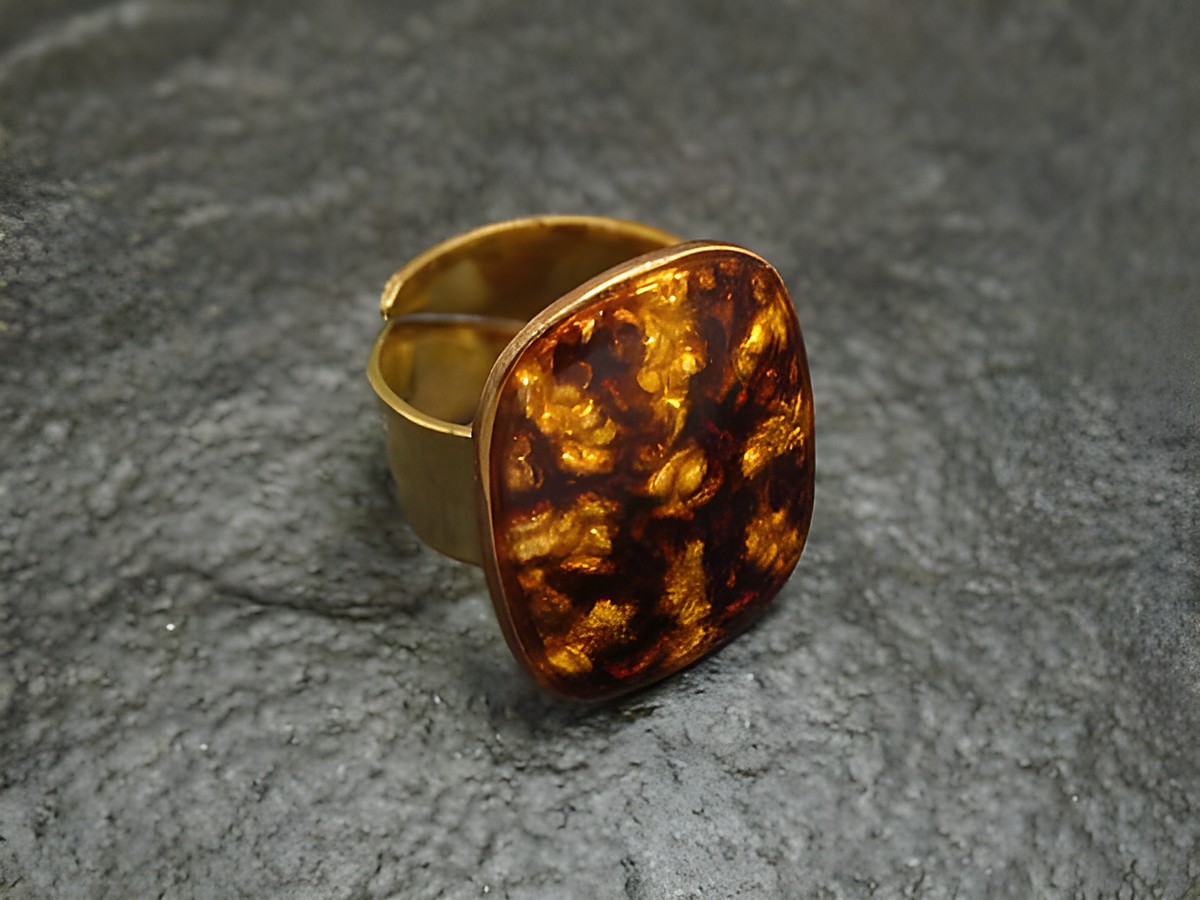 Ring mit braun-gelber Emaille, vergoldet, in der Größe 52-58, von Juwelier Harnisch, charakteristische Struktur und Farben, ideal für elegante Mode.
