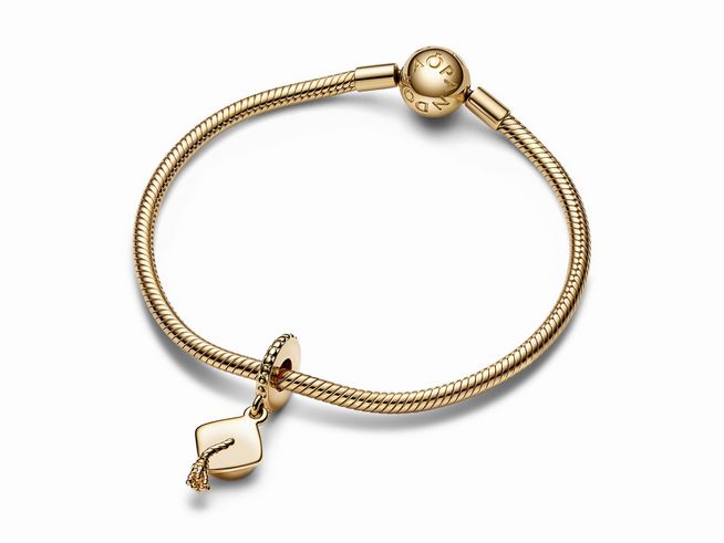 761892000-1 Ein eleganter Pandora Charm-Anhänger in Form einer Schulabschluss-Mütze aus gelbgold vergoldetem Material, an einer feinen, gewellten Armbandkette befestigt.