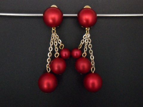 Dunkelrote Ohrclips aus Kunstharz mit goldfarbenem Detail, zeitloses Design, hängen mit feinen Ketten, elegant und edel, Hersteller Juwelier Harnisch.