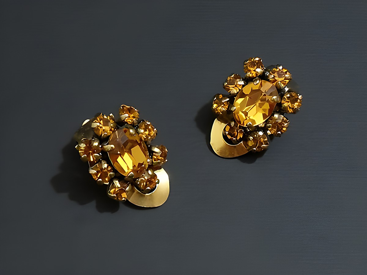 Strass Ohrclips in anmutigem Design in orange und goldfarben von Juwelier Harnisch, verziert mit funkelnden Strasssteinen, ideal für besondere Anlässe.