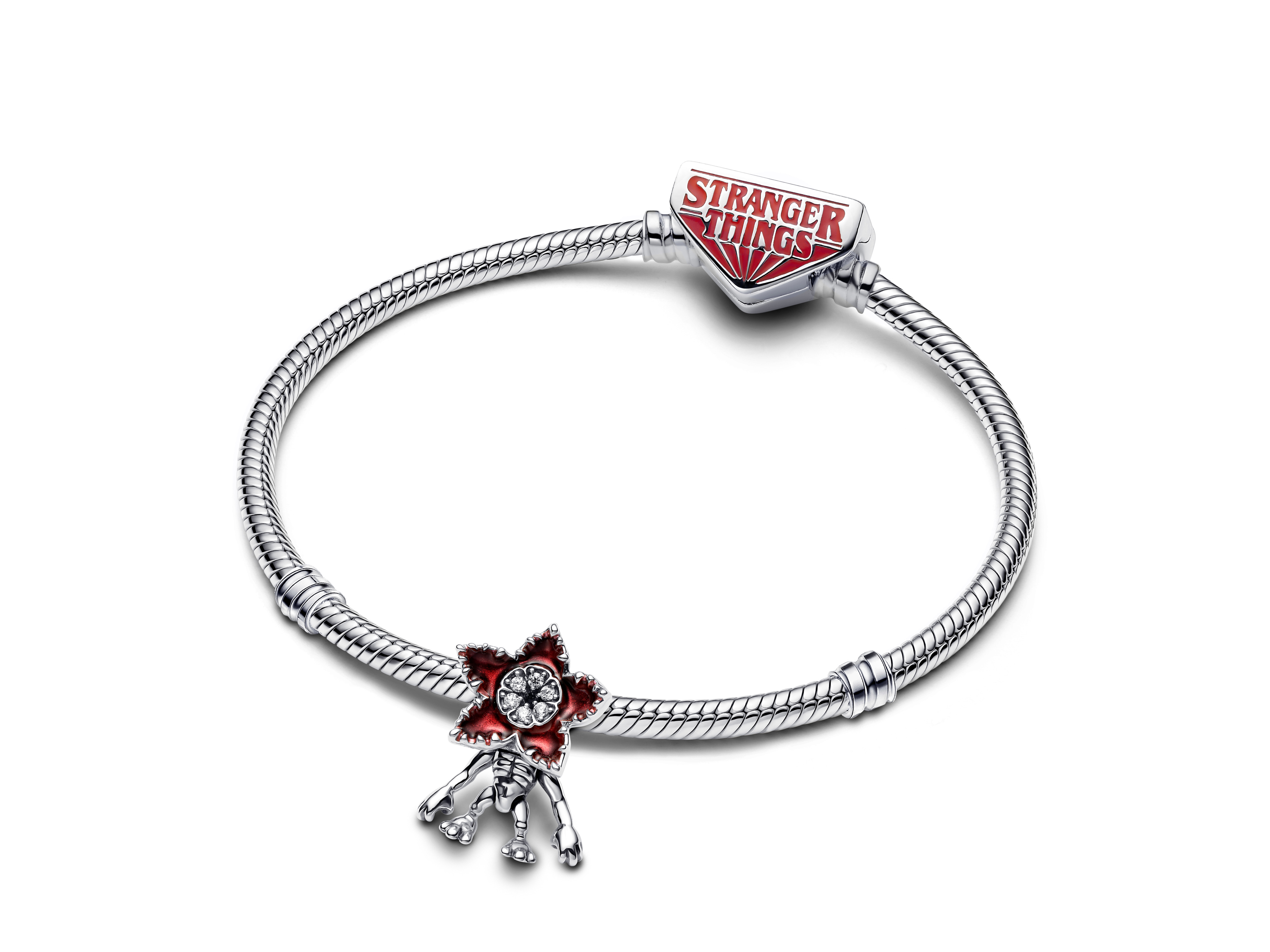 Pandora Charm 793562C01 aus Silber mit klarem Zirkonia, inspiriert von Stranger Things, zeigt eine rote Blume mit einem Skelett und dem Stranger Things Logo.