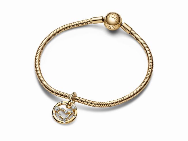 Ein eleganter Pandora Charm-Anhänger in Gelbgold mit dem Sternzeichen Steinbock und Zirkonia, der an einem feinen Armband hängt. Ideal für Schmuckliebhaber und als persönliches Geschenk.