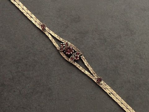 Strass Armband prunkvoll in lila mit goldfarbenem Design, verstellbar von 19 bis 21,5 cm, hergestellt von Juwelier Harnisch. Elegantes Schmuckstück für besondere Anlässe.