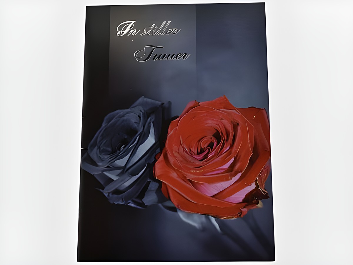 Auf der Trauerkarte sind eine schwarze und eine rote Rose abgebildet, mit dem Schriftzug In stiller Trauer. Hersteller ist Juwelier Harnisch, Trauerkarten.