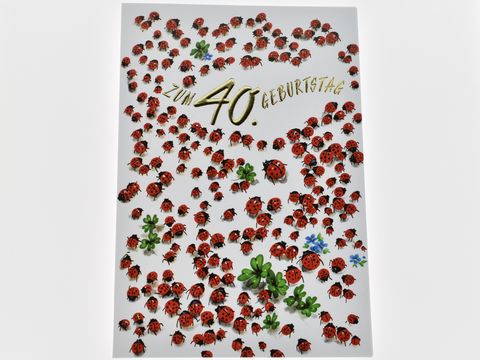 Eine Geburtstagskarte zum 40. Geburtstag, geschmückt mit zahlreichen roten Marienkäfern und einigen grünen Kleeblättern sowie blauen Blüten. Hersteller: Juwelier Harnisch.