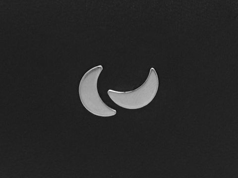 Edelstahl Ohrringe in Form von Monden, Ohrstecker des Herstellers Juwelier Harnisch, edelstahlfarbene Stecker, zeitloses Design auf schwarzem Hintergrund.