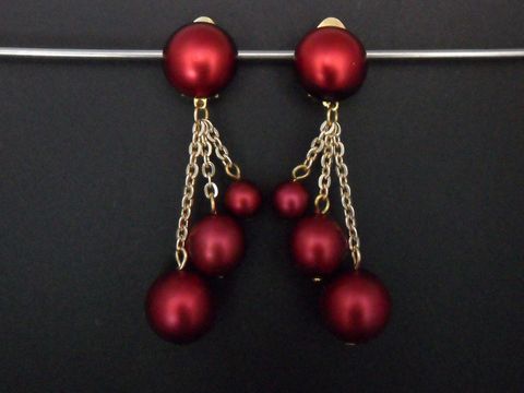 Weinrote Ohrclips mit goldfarbenen Elementen aus Kunstharz, zeitloses Design, ausgestattet mit Zierelementen in verschiedenen Größen und längeren Kettenanhängern, gleichzeitig elegant und auffällig.