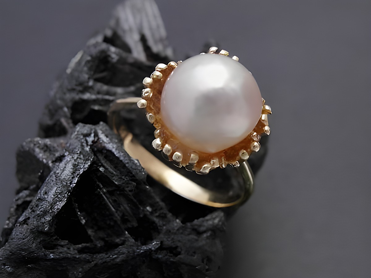 Gold Perlen Ring kunstvoll mit einer Zuchtperle von 9 mm aus Gold 585, Größe 52, Hersteller Juwelier Harnisch, bis Größe 52/17, auf schwarzem Hintergrund präsentiert.