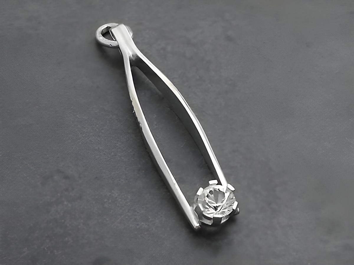 Silber Anhänger in Form einer Pinzette mit rhodiniertem Finish und einem Zirkonia Stein, hergestellt von Juwelier Harnisch. Der Anhänger ist elegant und zeitlos.
