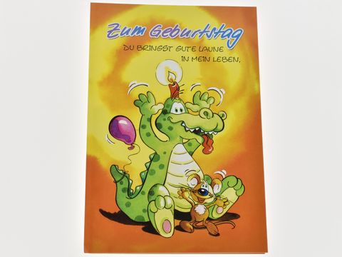 Eine bunte Geburtstagskarte mit einem lustigen Dino, der einen Luftballon hält und eine Kerze auf dem Kopf hat. Neben ihm steht ein kleiner brauner Freund. Der Titel lautet "Zum Geburtstag".