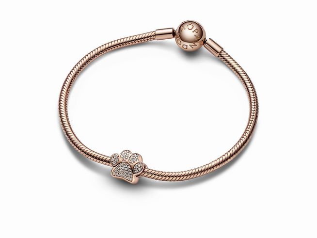 Funkelnder Pfotenabdruck Charm von Pandora in 585 Roségoldvergoldung, verziert mit klaren Zirkoniasteinen, zeigt eine stilisierte Pfote auf einem eleganten Armband.