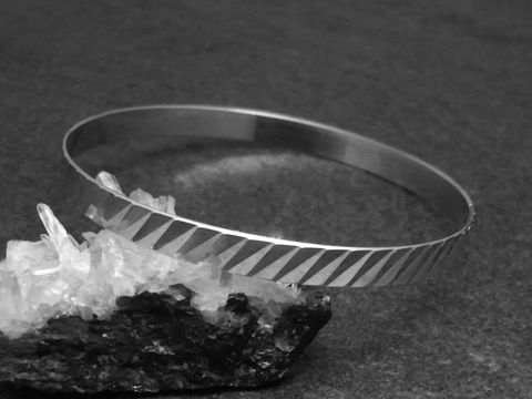 Silber Armreifen im Disco-look mit einer Breite von 6,1 mm und rhodiniert, Länge 20 cm, Hersteller: Juwelier Harnisch, elegant und modern auf schwarzem Hintergrund präsentiert.
