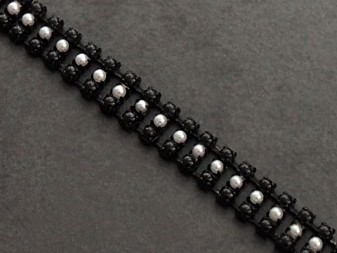 Modeschmuck Armband in schwarz und weiß mit einer Länge von 17,5 cm, hergestellt von Juwelier Harnisch. Das Armband besteht aus Strass und hat ein elegantes Design.
