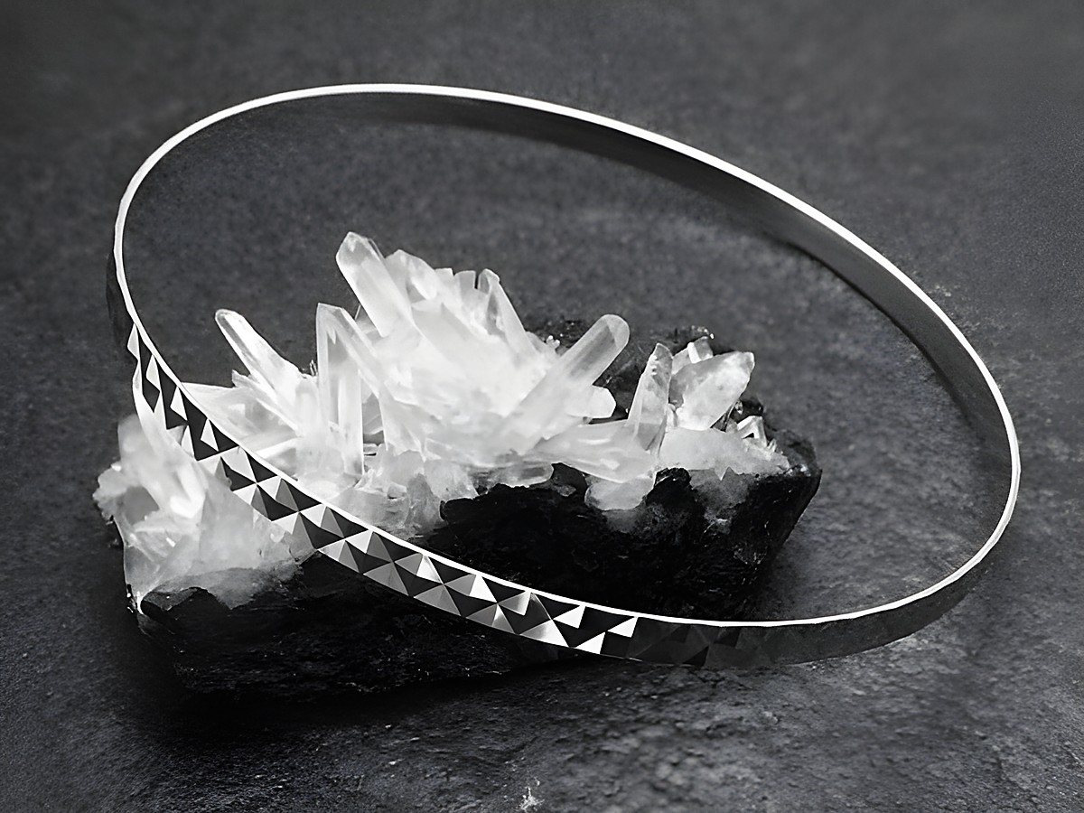 Silber Armreifen im sexy City Look, rhodiniert, 3,4 mm Breit und 21 cm Umfang, Hersteller Juwelier Harnisch, elegant auf einem Kristalluntergrund präsentiert.