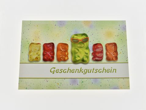 Eine Gutscheinkarte mit bunten Bärchen, einer Bärchenfigur mit Sonnenbrille in der Mitte, und dem Aufdruck Geschenkgutschein, gestaltet für den Juwelier Harnisch.