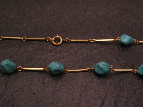 Kette im Türkislook 66 cm lang und 10x9 mm breit, hergestellt von Juwelier Harnisch, aus Stein mit goldfarbenen Gliedern. Ideal für elegante Anlässe.