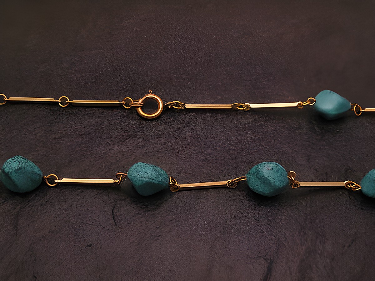 Kette im Türkislook 66 cm lang und 10x9 mm breit, hergestellt von Juwelier Harnisch, aus Stein mit goldfarbenen Gliedern. Ideal für elegante Anlässe.