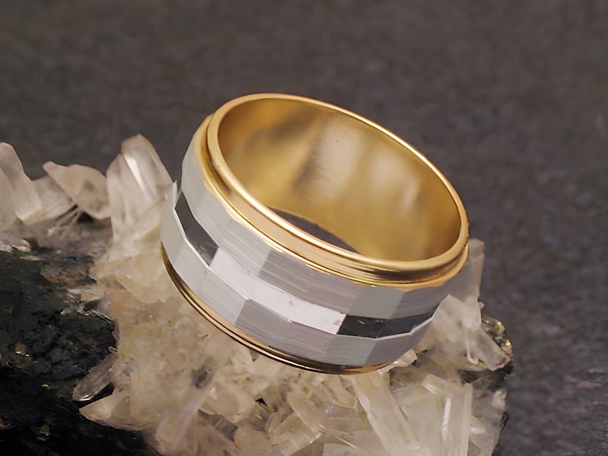 Bicolor City Party Ring, 9,7 mm breit, Größe 50 / 16 mm, aus Metall mit goldfarbener Innenseite und einem geometrischen Muster in Schwarz und Weiß, präsentiert auf einem kristallähnlichen Untergrund.