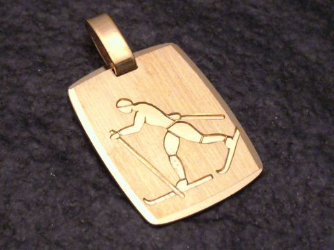 Gold Anhänger mit einer Darstellung eines Skilangläufers, der im Wintersport aktiv ist. Hergestellt von Juwelier Harnisch, ideal für Sportliebhaber und als Schmuckstück für besondere Anlässe.