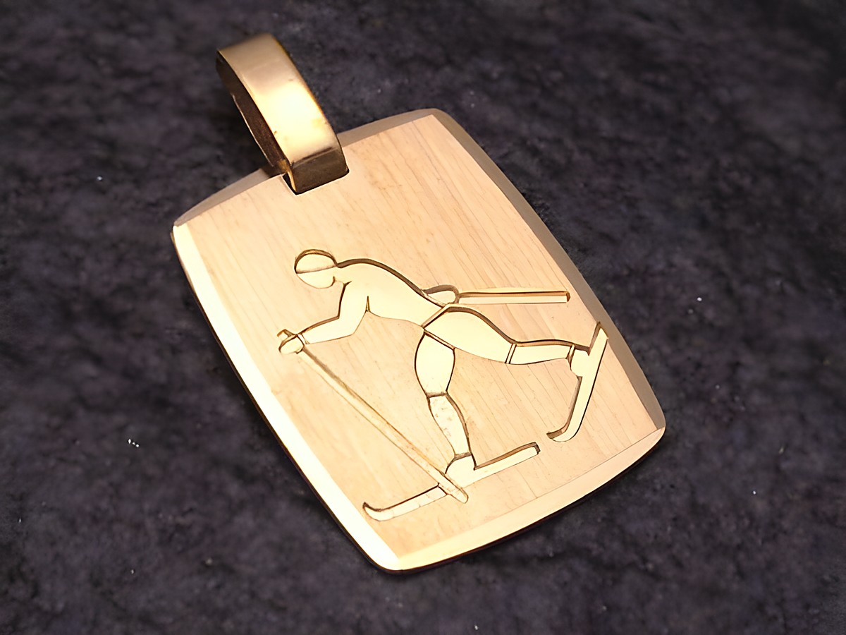 Gold Anhänger mit einer Darstellung eines Skilangläufers, der im Wintersport aktiv ist. Hergestellt von Juwelier Harnisch, ideal für Sportliebhaber und als Schmuckstück für besondere Anlässe.