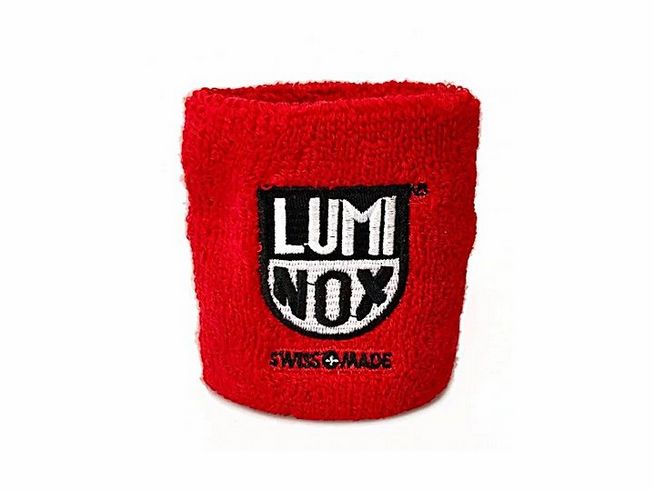 Luminox Schweißband in leuchtendem Rot mit schwarzem Luminox Logo und der Aufschrift Swiss Made, ideal als Zubehör für die Luminox Uhrenbox.