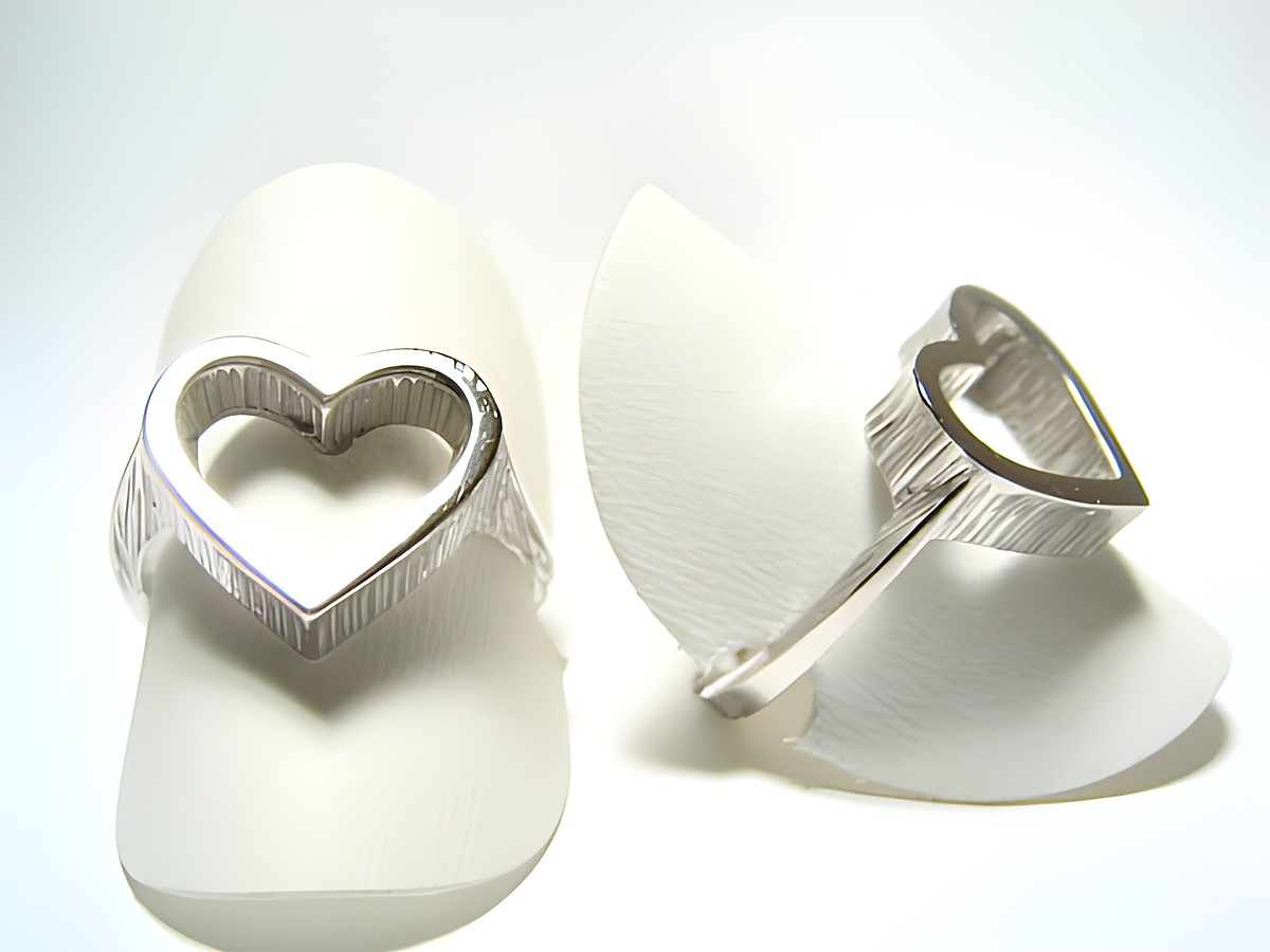 Silber Ring rhodiniert in Herzform, Größe verstellbar, ohne Stein, Hersteller Juwelier Harnisch, auf weißem Hintergrund abgebildet.