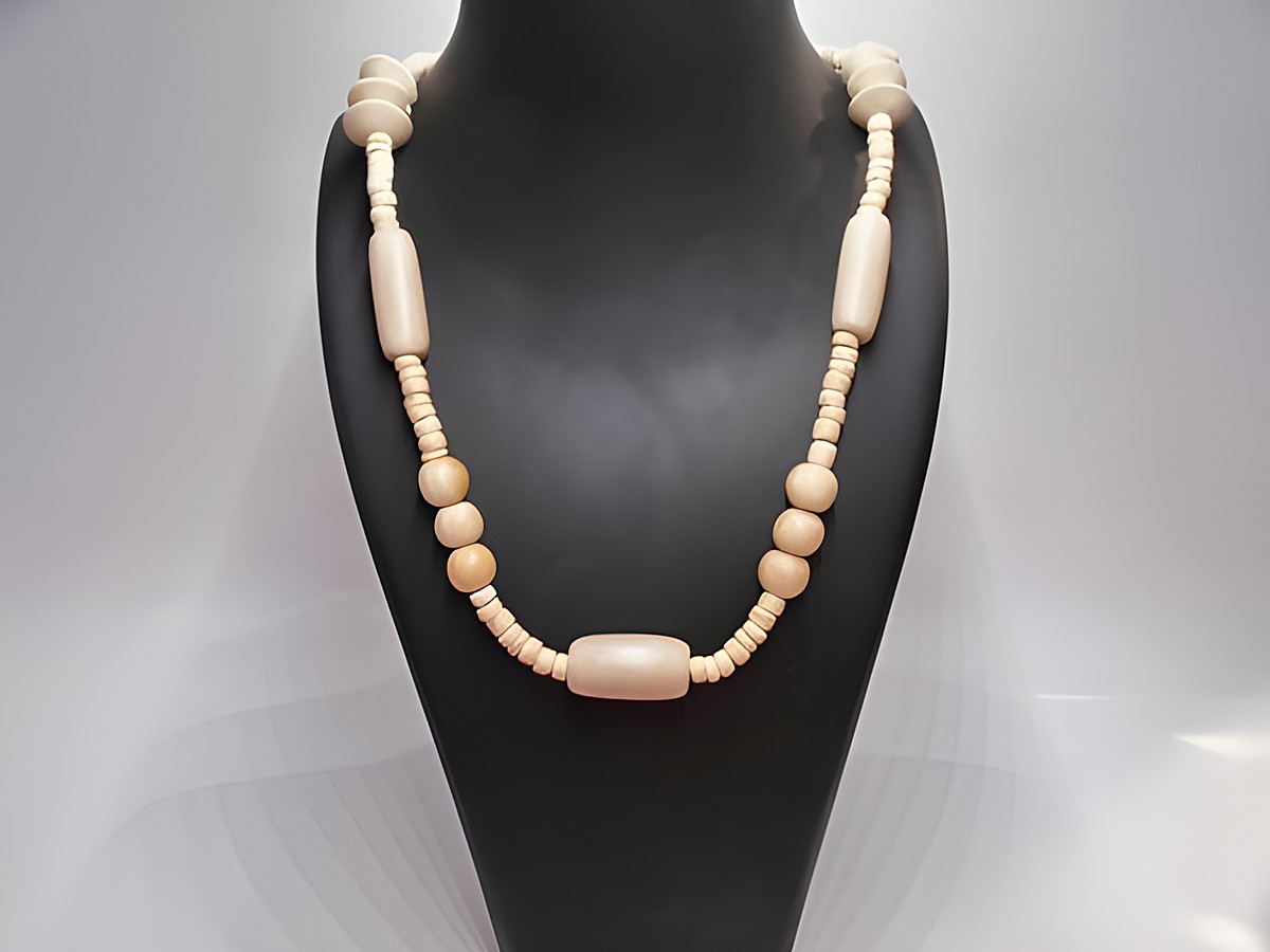 Naturbraune Holzkette mit einer Länge von 60 cm, aus verschiedenen Holzperlen gefertigt, präsentiert auf einem Halter, ideal als Schmuckstück von Juwelier Harnisch.