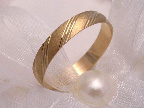 Trauring Ehering PRETTY aus Gold 333 in Größe 65/20,7 des Herstellers Juwelier Harnisch, dekoratives Muster auf der Oberfläche, elegant auf einem weißen Band mit einer Perle präsentiert.