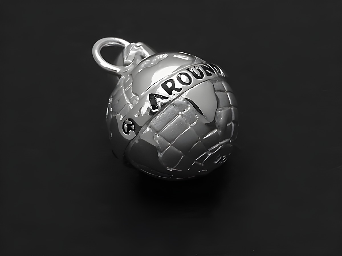 Silber Anhänger in Form einer Weltkugel mit dem Schriftzug AROUND THE WORLD in schwarz-rot, verziert mit Sonne, Mond und Sternen, Hersteller Juwelier Harnisch.