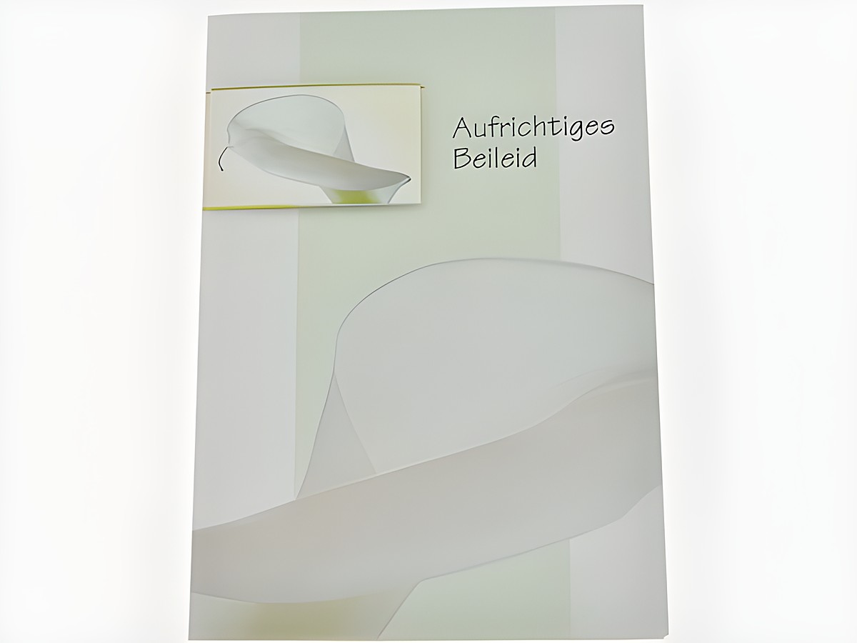 Trauerkarte mit Umschlag, auf der eine weiße Blüte abgebildet ist. Die Karte trägt die Aufschrift Aufrichtiges Beileid und stammt vom Hersteller Juwelier Harnisch.