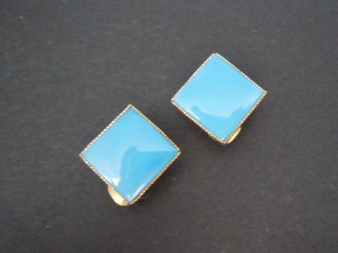 Türkise Ohrclips aus Kunstharz mit goldfarbener Umrandung, zeitloses Design, gefertigt von Juwelier Harnisch, ideal für elegante Anlässe.