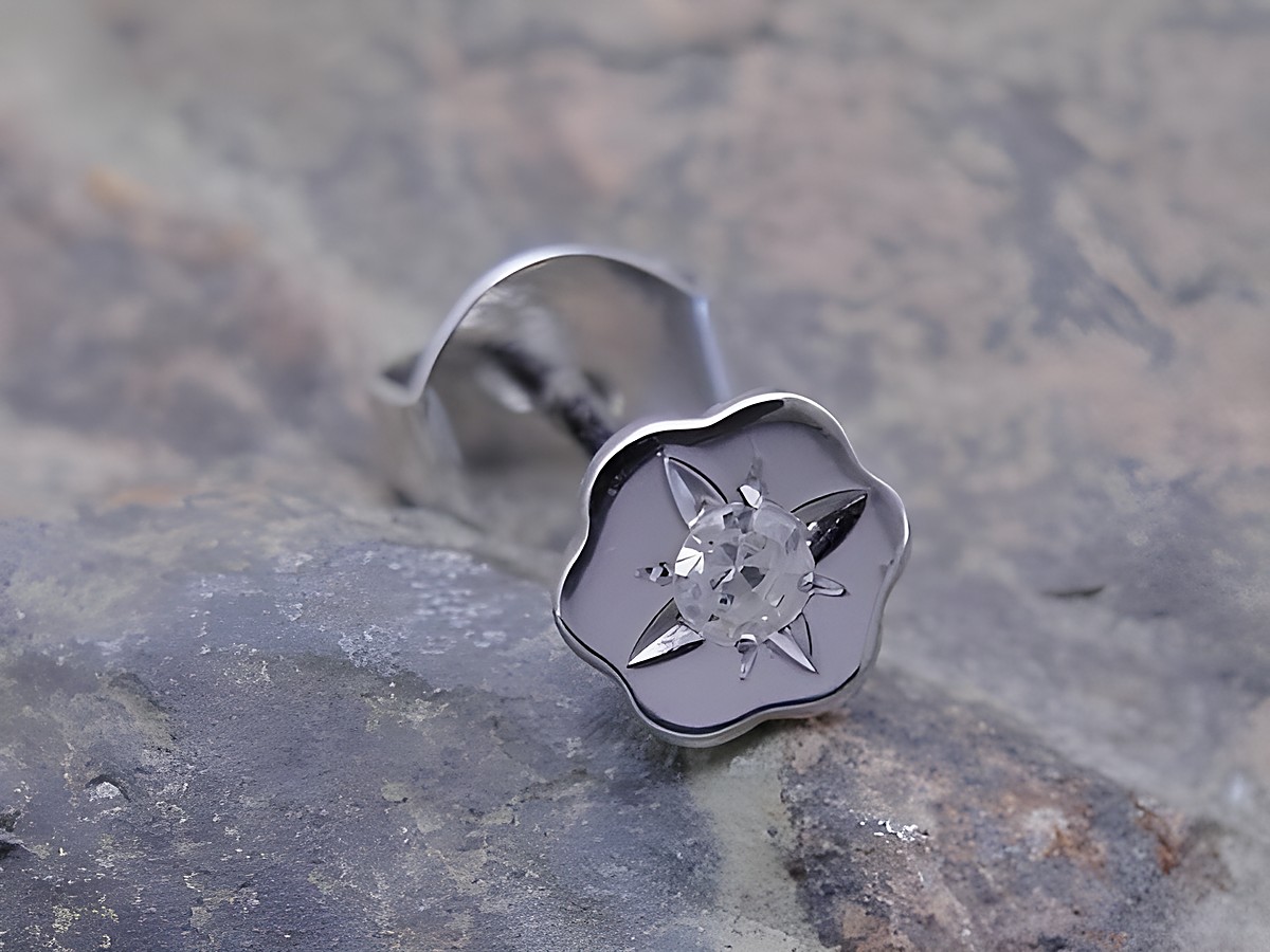 Ein kunstvoller Ohrstecker in Blumenblütenform aus Weißgold, verziert mit einem Diamanten. Ein elegantes Schmuckstück für jede Gelegenheit, hergestellt von Juwelier Harnisch.