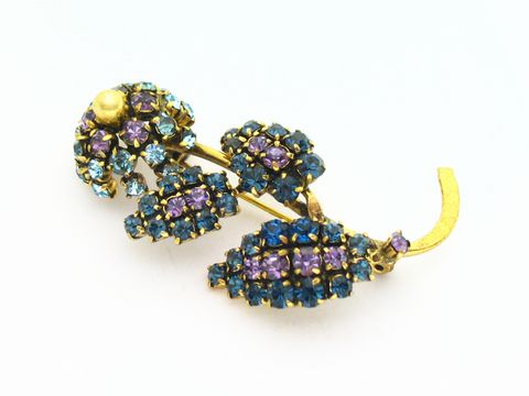 Brosche mit lila Blume im Sexy City Look, von Juwelier Harnisch, verziert mit Strasssteinen in verschiedenen Blau- und Lilatönen, elegantes Einzelstück für besonderen Anlass.