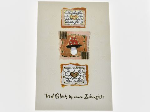 Geburtstagskarte mit Herzen, gestaltet von Juwelier Harnisch, zeigt eine farbenfrohe Illustration mit einem Pilz und goldenen Akzenten, umrahmt von liebevollen Texten und Glückwünschen für das neue Lebensjahr.