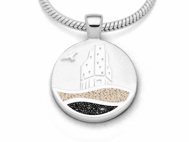 Der Anhänger zeigt eine stilisierte Darstellung eines Gebäudes mit Wellen und Sand in den Farben Strandsand und Lavasand, gefertigt aus rhodiniertem Sterling Silber von DUR.
