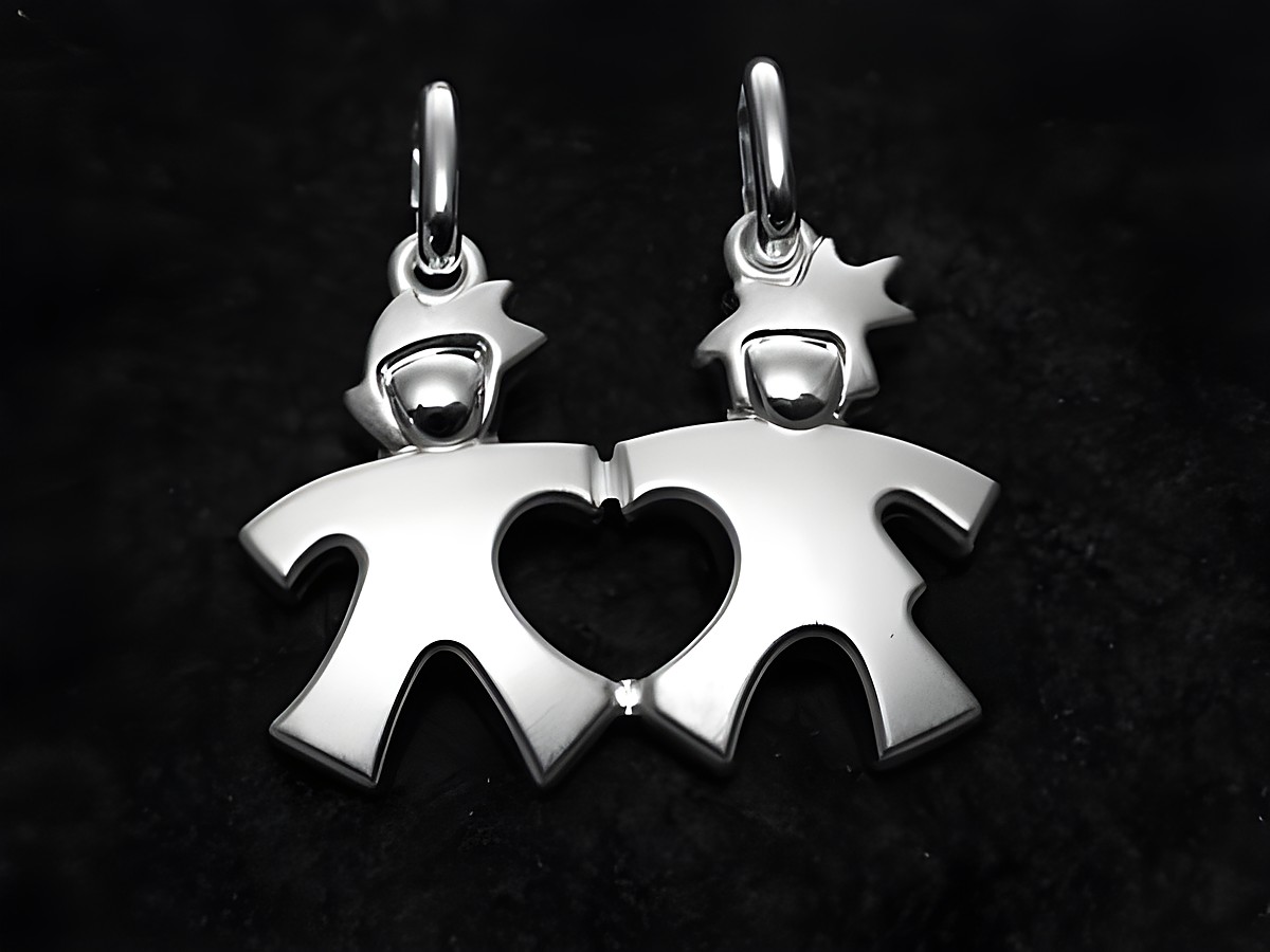 Zwei Partneranhänger aus Sterling Silber in Form von stilisierten Figuren mit einem Herz in der Mitte, hergestellt von Juwelier Harnisch, Symbol für Freundschaft und Verbundenheit.