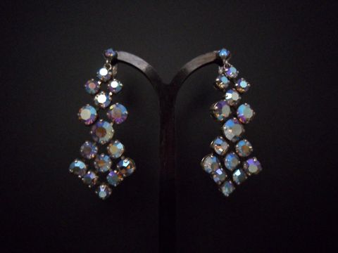 Bunte schimmernde Ohrclips aus Strass, originell und silberfarben, hergestellt von Juwelier Harnisch, in elegantem Design als Ohrhänger sichtbar.