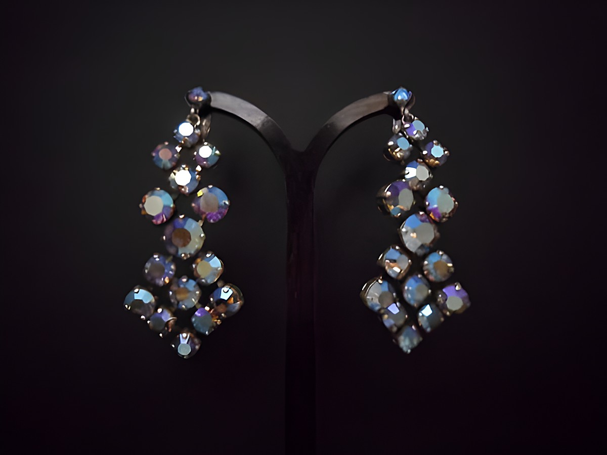 Bunte schimmernde Ohrclips aus Strass, originell und silberfarben, hergestellt von Juwelier Harnisch, in elegantem Design als Ohrhänger sichtbar.